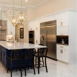 angielska kuchnia z granatowa, duzą wyspą i krzesłami, dwudrzwiowa lodówką oraz meblemi kuchennymi w kolorze białym