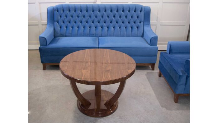 okrągła ława na płozach w stylu art deco na wysoki połysk. Niebieska sofa trzy osobowa, sofa z pikowanym oparciem.